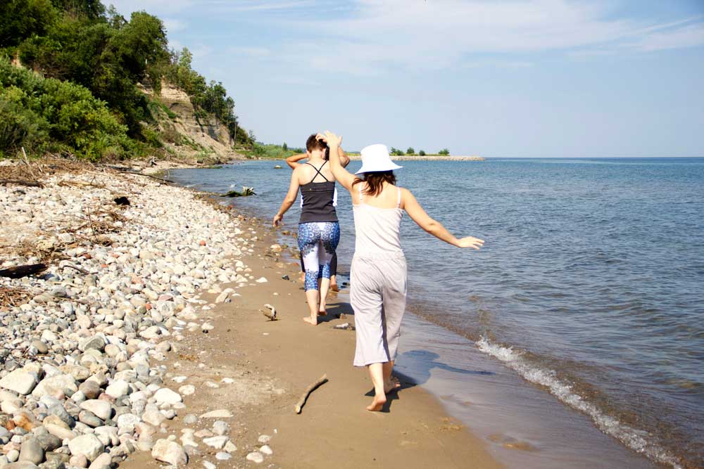 3 sisters walking along the beach barefoot